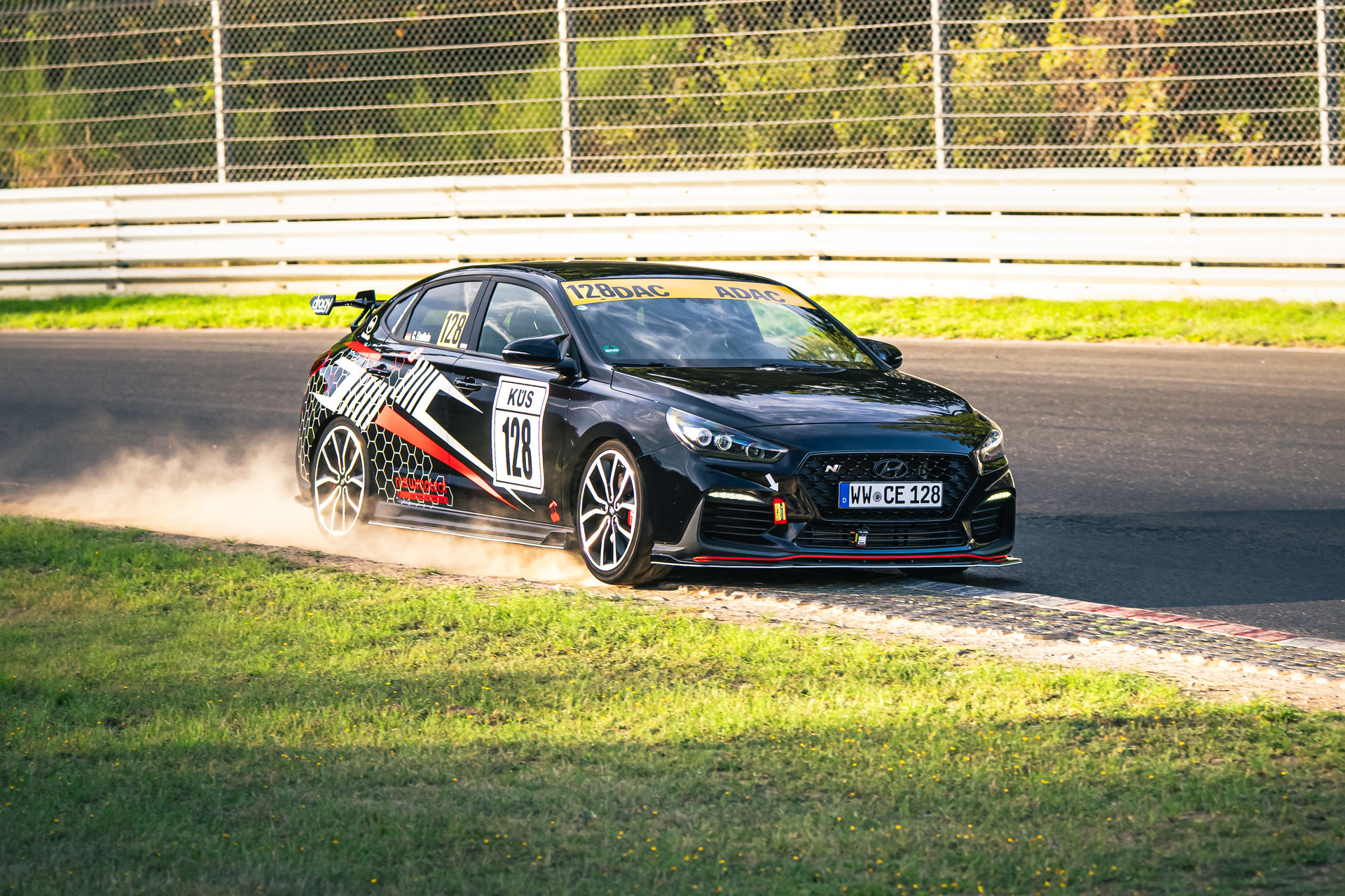 Fahrerin im Rennanzug vor ihrem Hyundai mit Startnummer 128 am Nürburgring